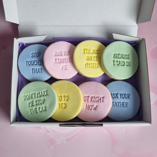 box of multicoloured cookies with various sayings on them